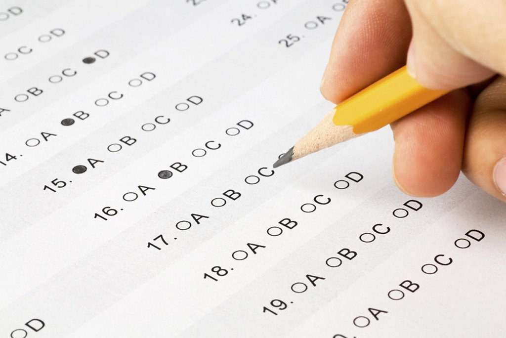 Elève complétant un questionnaire à choix multiples au crayon pendant ses révisions du brevet