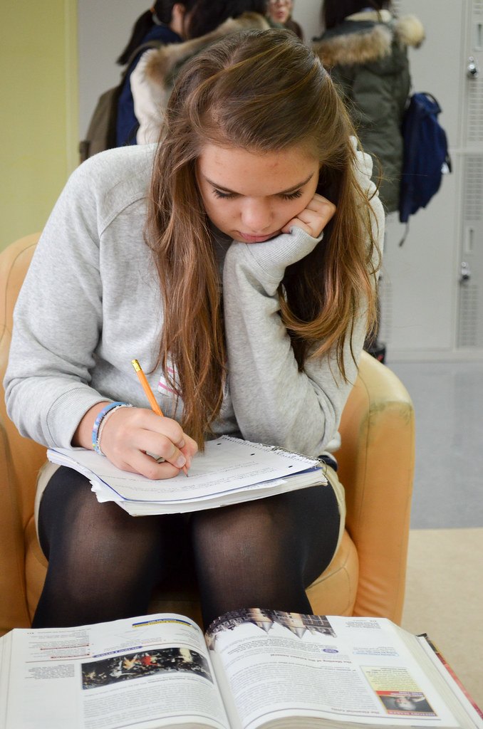 Etudiante concentrée en train d'écrire pour préparer sa session de rattrapage BTS